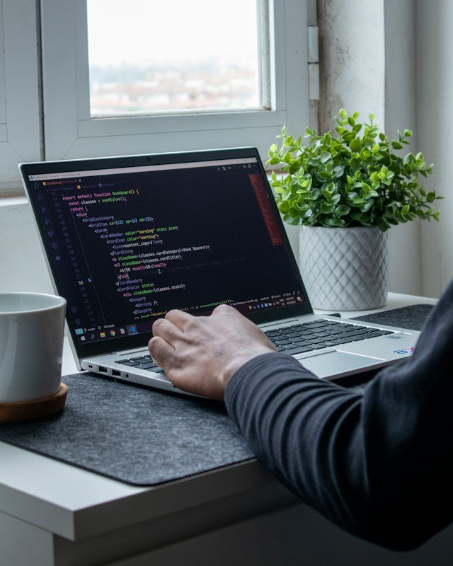 stock image of a person using a laptop with html on the screen